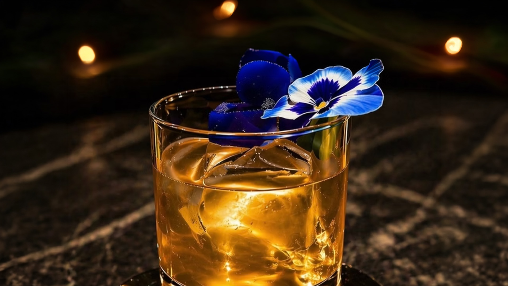 Whiskey cocktail with blue flower garnish