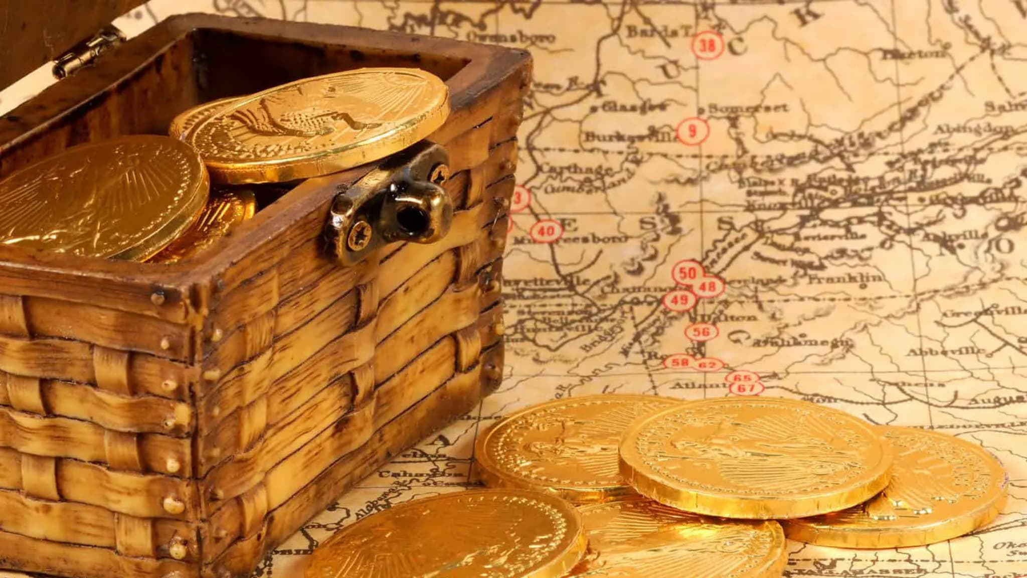 Wooden treasure chest with gold coins on map