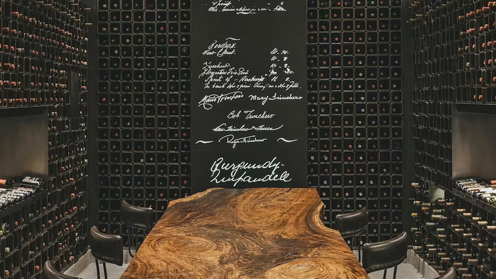 Elegant wine cellar with wooden table and shelves.