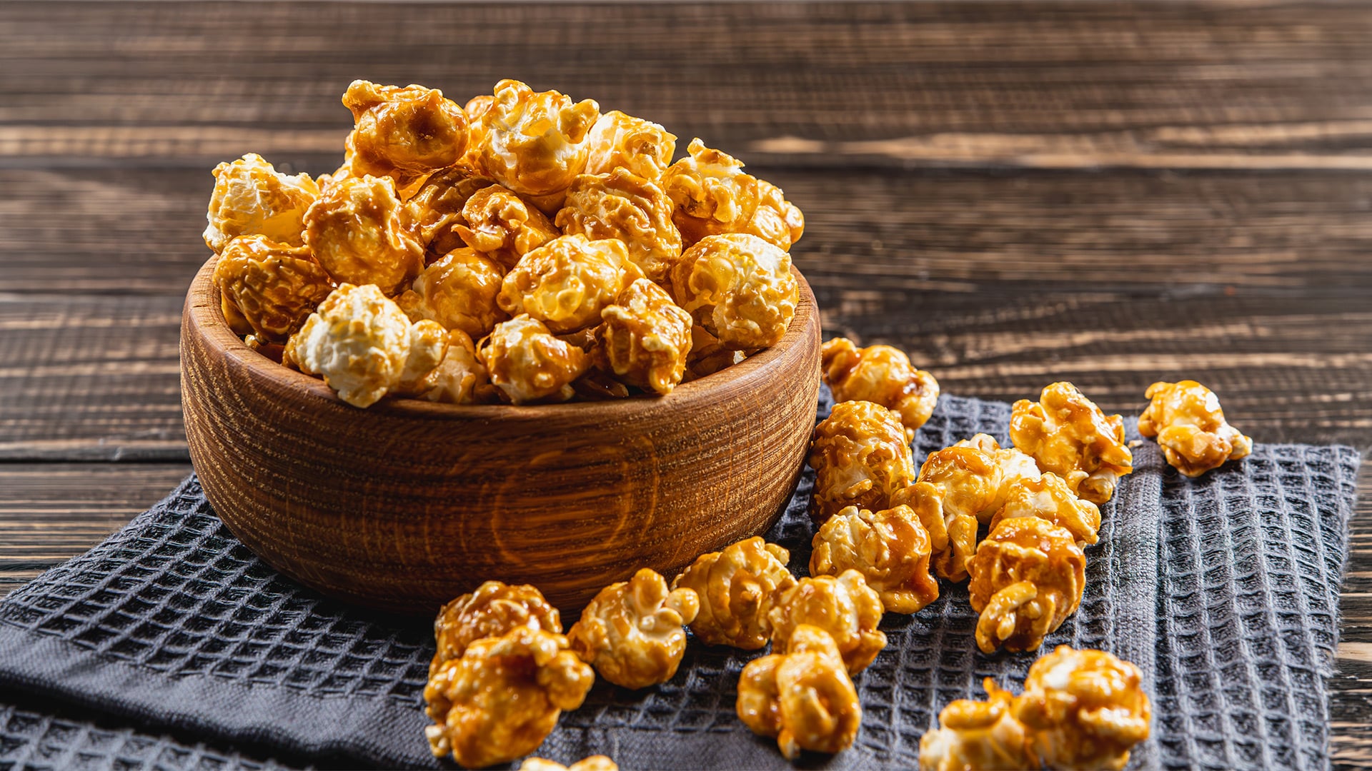 Bowl of caramel popcorn on a rustic wooden table