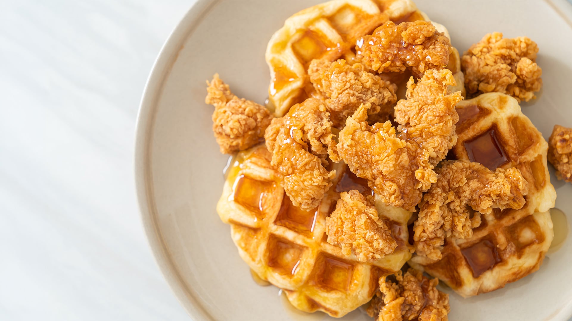 Crispy fried chicken and waffles drizzled with syrup
