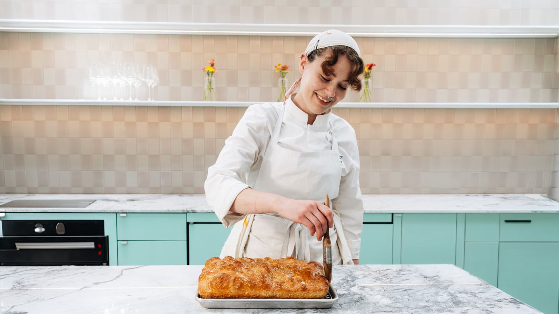 Chef brushing glaze on freshly baked bread