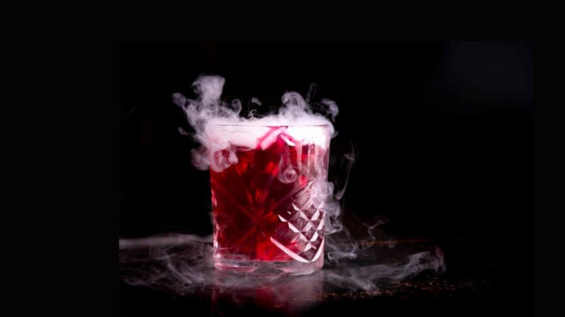 Smoky red cocktail in crystal glass.