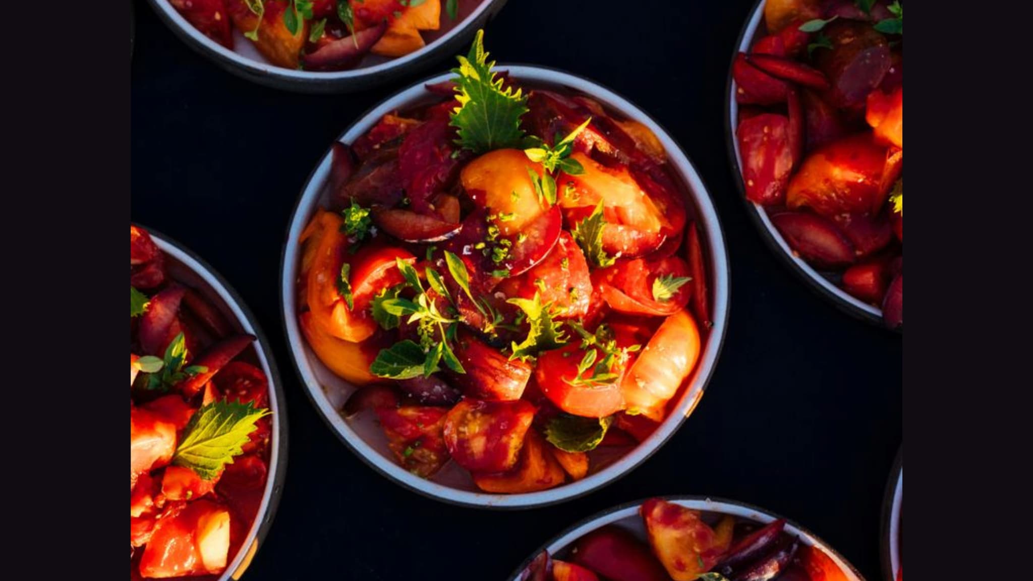 Bowls of tomato and peach salad with herbs