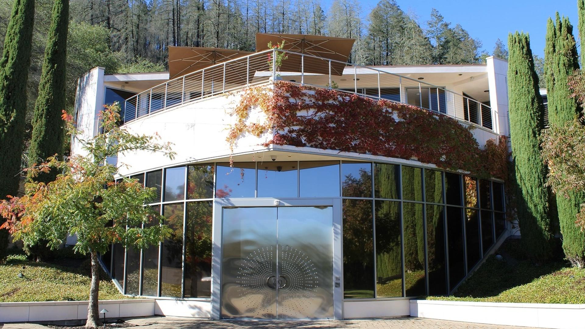 Modern glass building with lush greenery