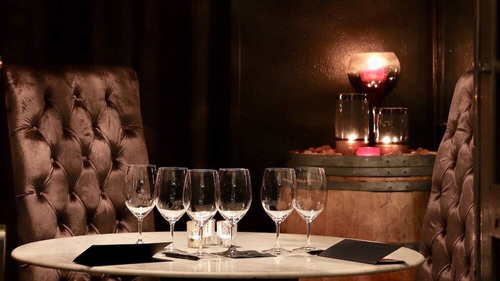 Cozy restaurant table with wine glasses and candles.