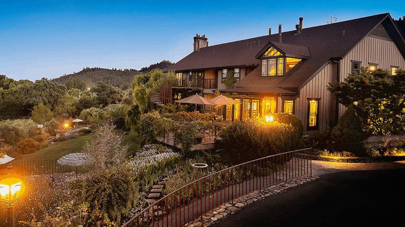 Charming house with lush garden at dusk.