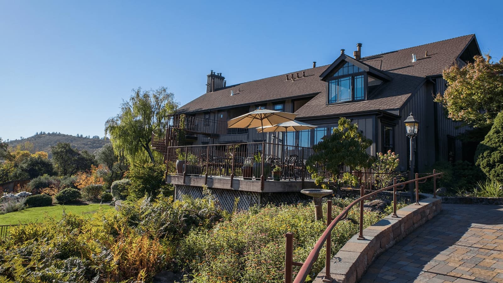 Large house with a garden and deck.