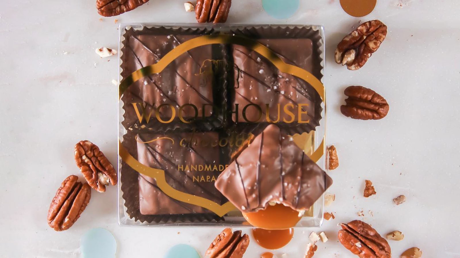 Woodhouse chocolates with pecans and caramel spilling out.