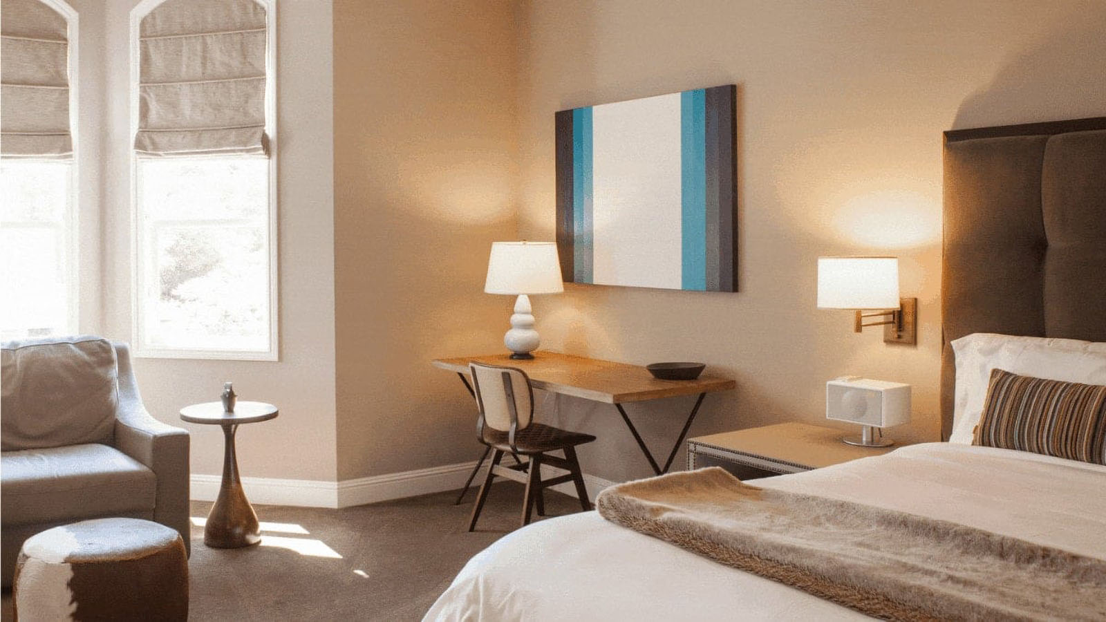 Modern bedroom with desk and lamp.