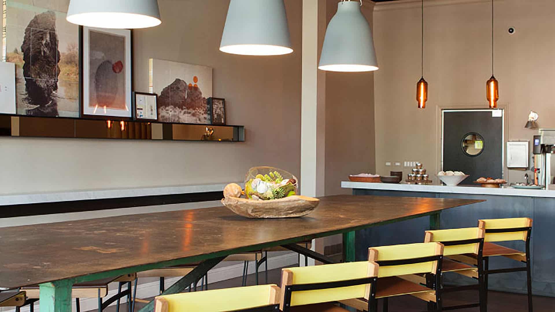 Modern dining area with hanging lights and artwork.