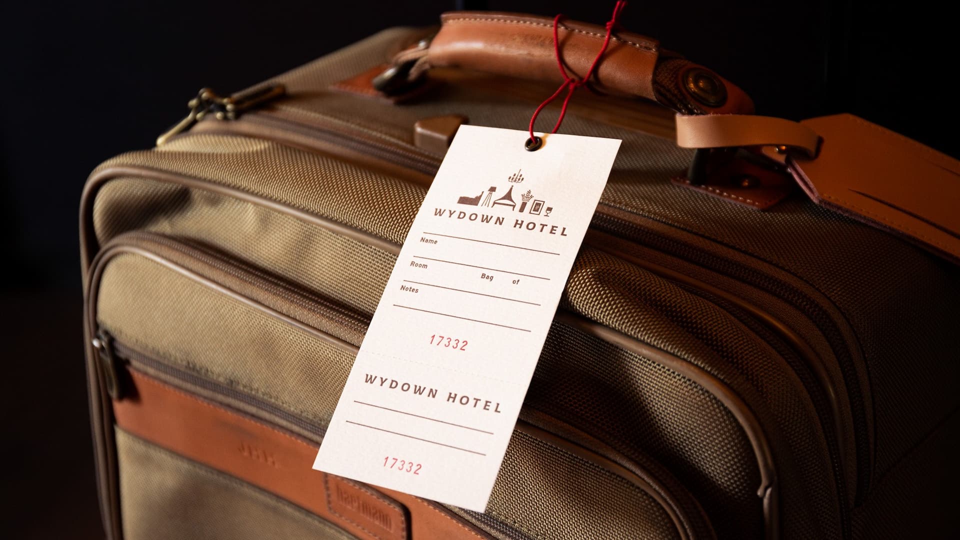 Brown suitcase with Wydown Hotel tag attached